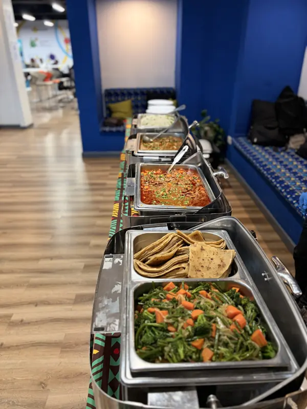 Lunch buffet line along a blue wall