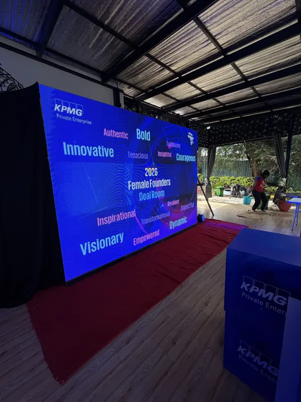 A corporate stage with an LED screen and red carpet